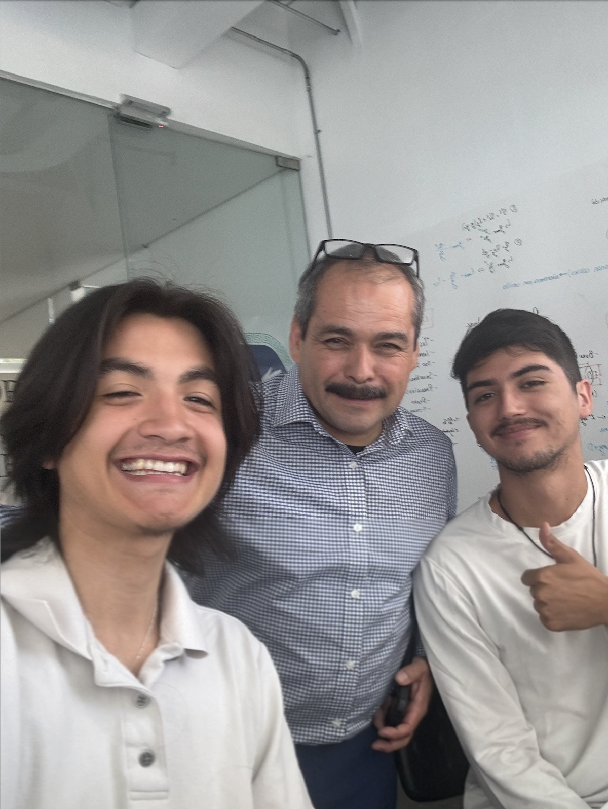 Selfie of Jonathan Beas with supervisor in the middle and Cristopher Miranda posing with a thumbs up