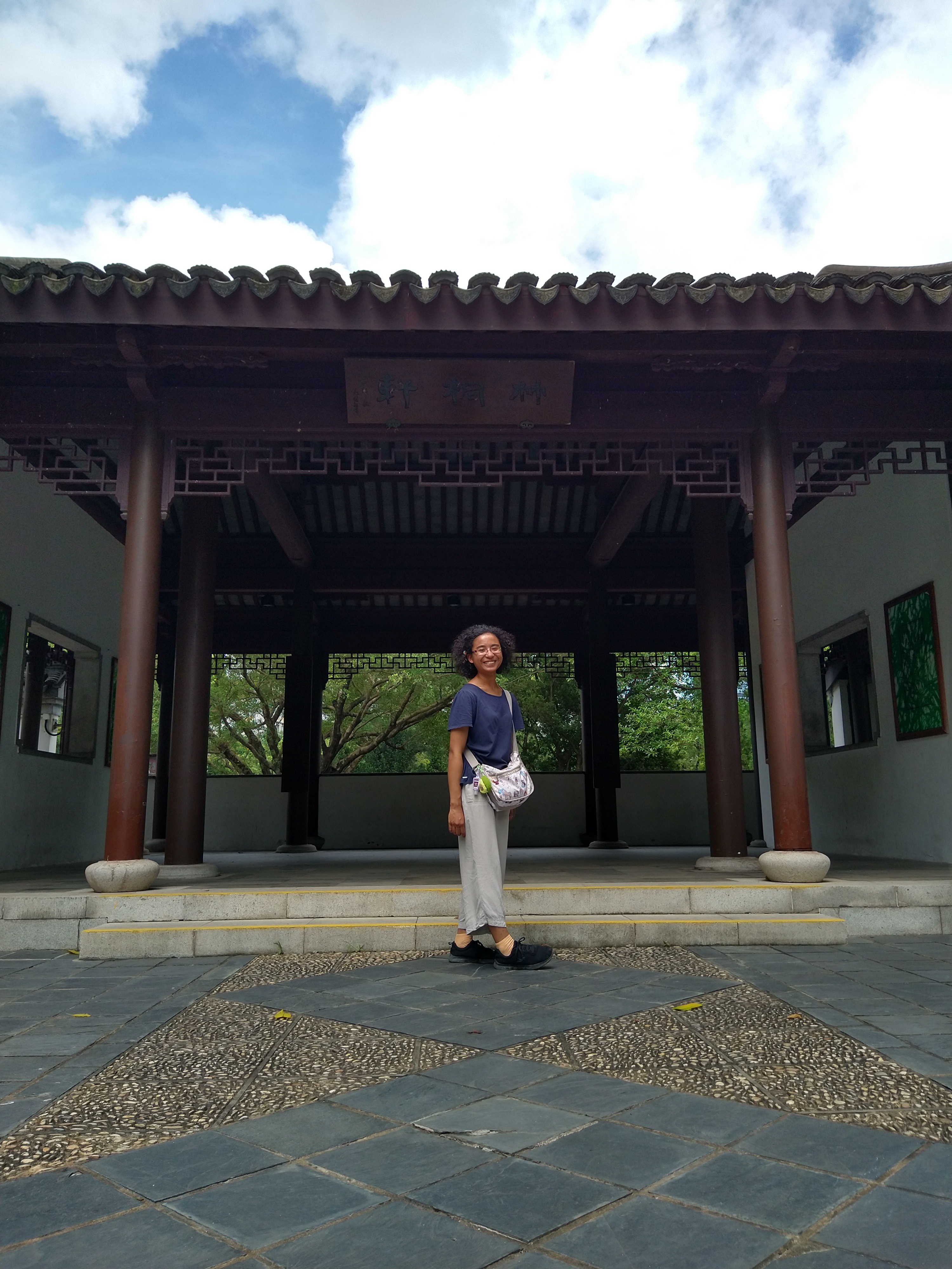 Jolie Duquene posing in front of a traditional Chinese red awning in Hong Kong