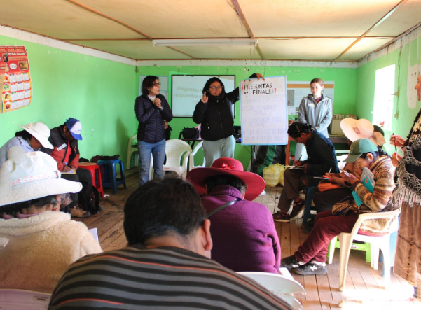Alison Rufo in a classroom while locals presented to a room fill of people seated on plastic chairs in Peru