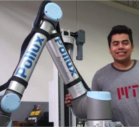 Alexis Vivar posing next to a robotic arm
