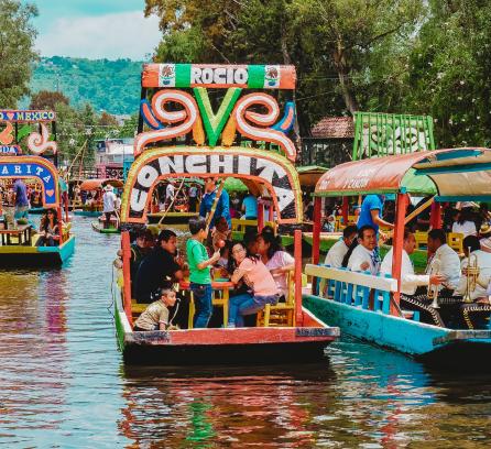People riding colorful boats in Mexico City