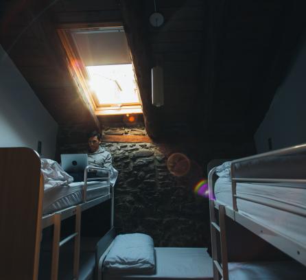 Man sitting in bed in hostel room