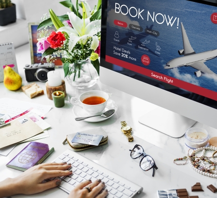 woman booking flight on computer at desk