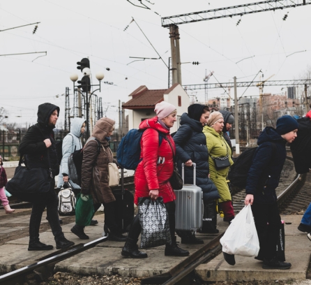 Lviv, Ukraine - March 3, 2022: Having just disembarked a train, people walk with their luggage across the tracks in Lviv. Credits: Image: iStock