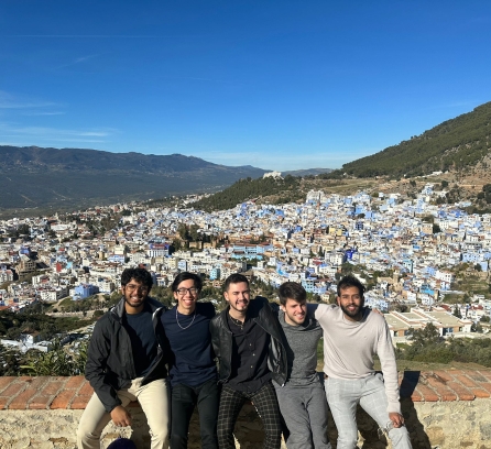 5 students in front of city backdrop