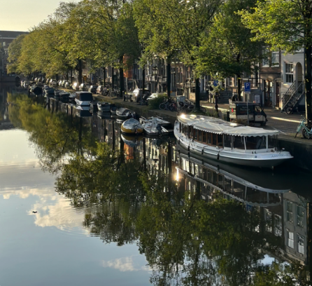 Sunset over the Amstel Rive with boats along the bank