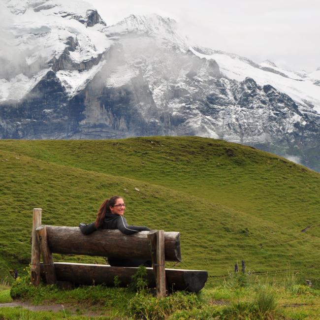 Student Nina on a bench in front of a mountain