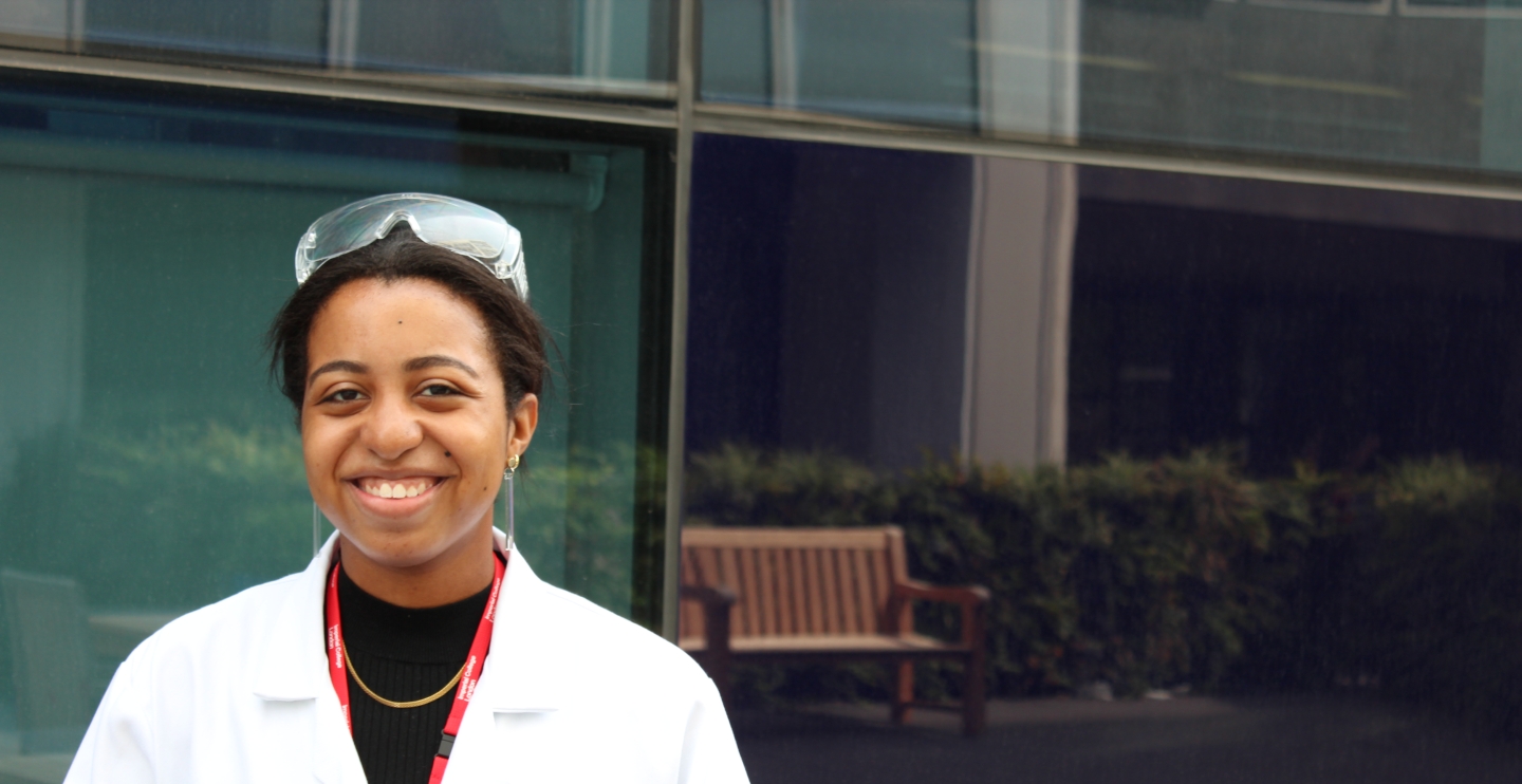 Student with white lab coat and safety goggles
