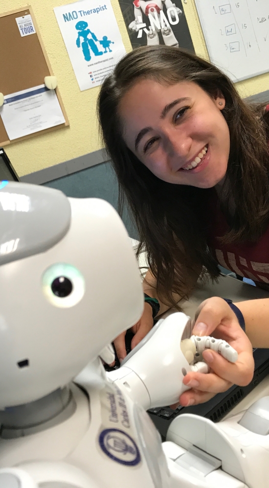 Kyra Post posing next to a friendly looking robot assistant