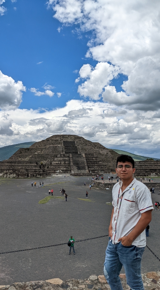 Headshot of Maximiliano Ramirez on a cloudy day with Teotihuacan and other tourists in the background