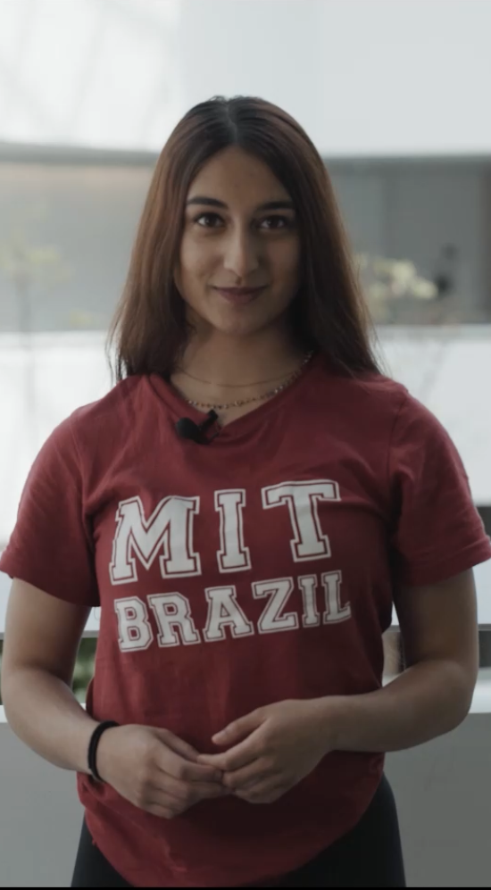 Mid shot of Prathysha Kothare in a maroon MIT-Brazil program shirt standing along the white corridor of Hospital Israelita Albert Einstein in Sao Paolo, Brazil