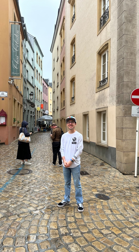Ian Rosado rocking a cap in an alley in Luxemborg with the pavement tiled with bronze bricks