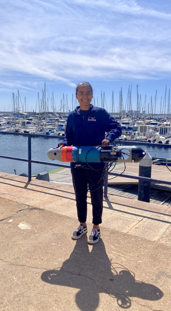 Erin holding a light autonomous underwater vehicle