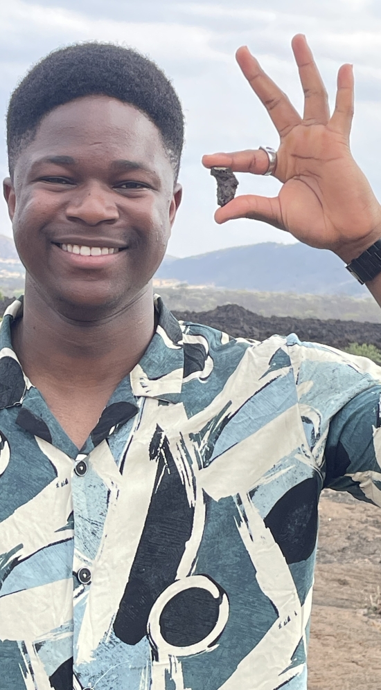 Nickie Mpofu holding a rock that is shaped like the continent of Africa