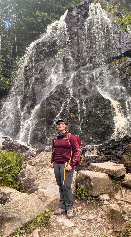 Tamara Hinderman in front of waterfall while on a hike in Germany