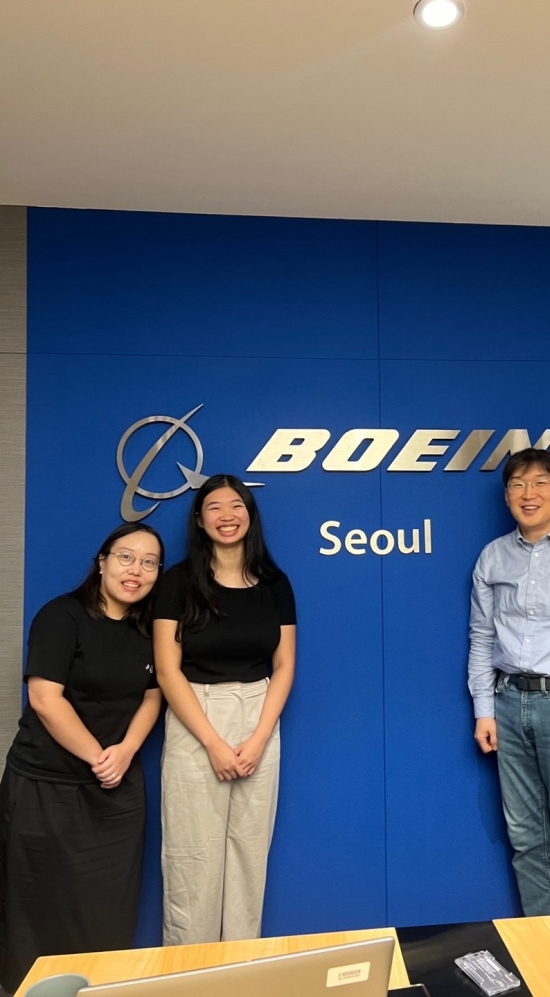 Amanda Tong standing with 3 other colleagues in front of the Boeing logo in Seoul