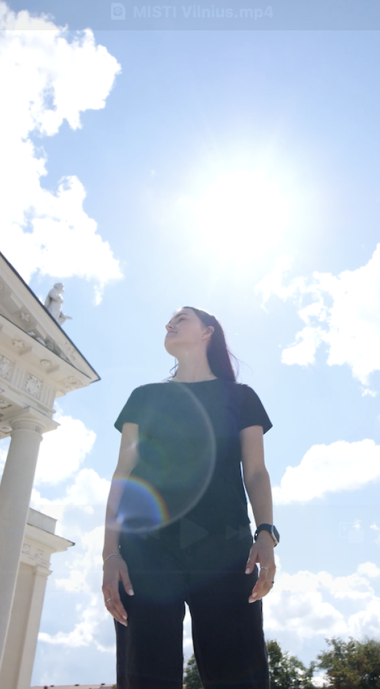 Inna Voloshchuk standing in between the two buildings the Vilnius Cathedral in Armenia