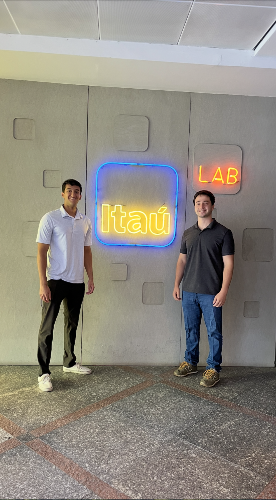 Lucas Puig standing infront of the Itaú bank yellow neon sign 