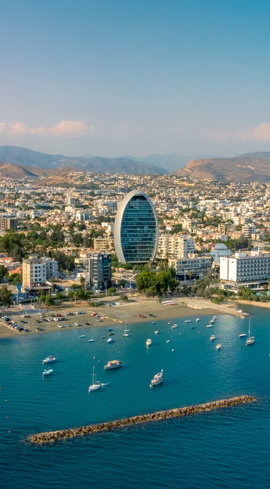 Picture of the coast of Cyprus with a dense city of buildings and a mountainous region in the horizon