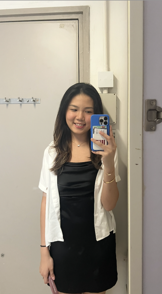 Christina Ding smiling in a mirror while holding her phone