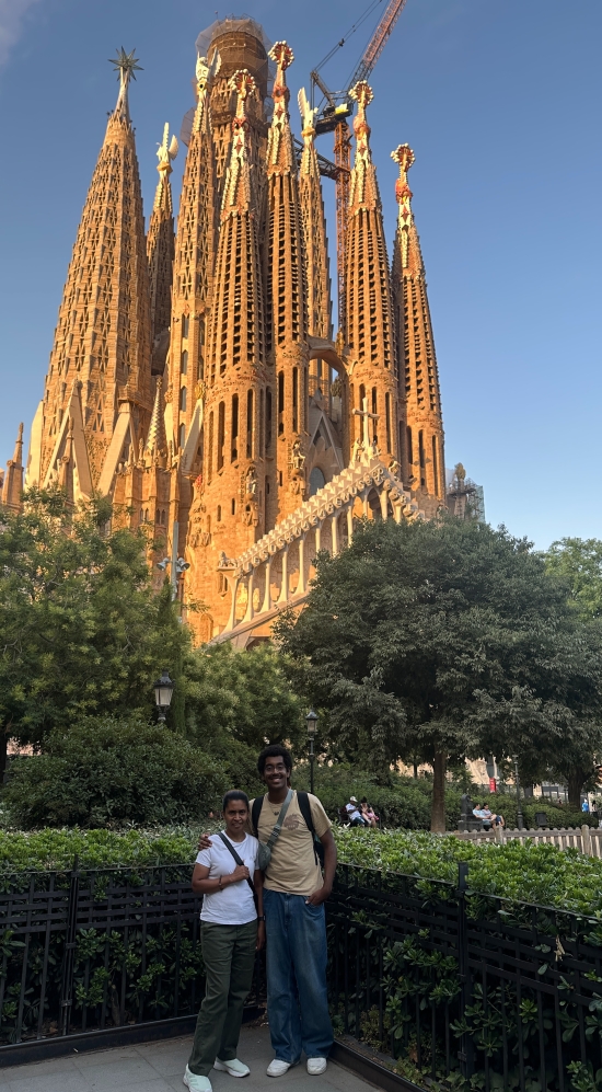 Caleb standing with a friend with the La Sagrada in the background