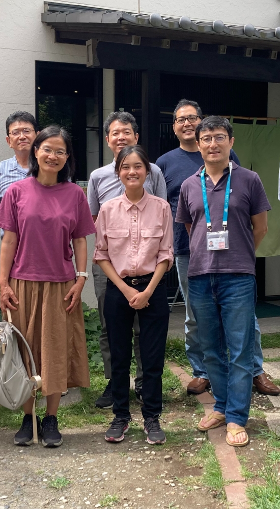 Sheila standing in the middle with 10 colleagues from NIERs outside an entrance to a home 