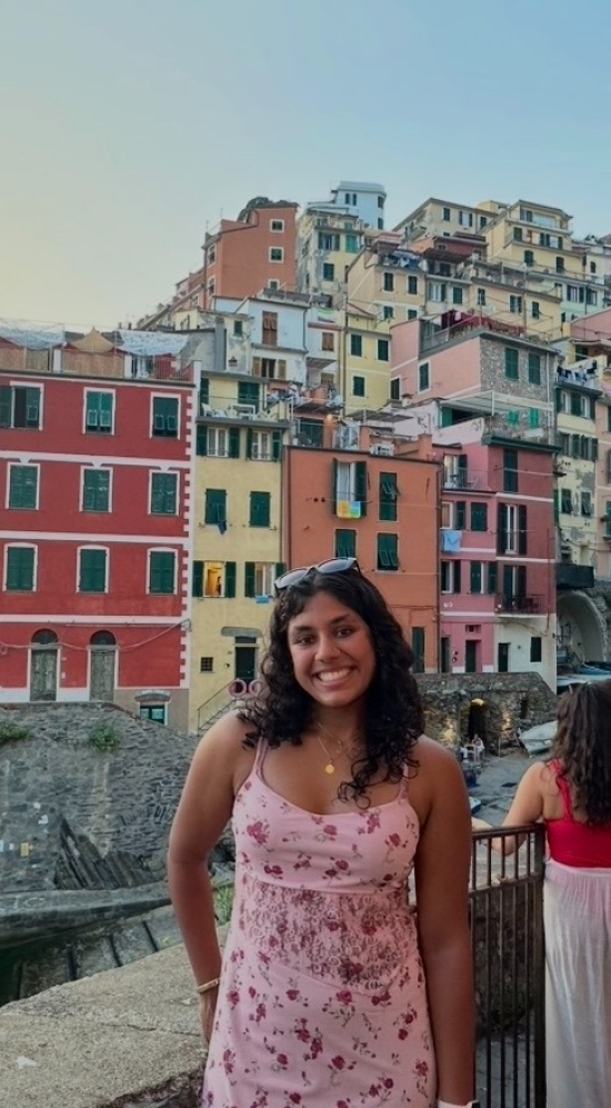 Shriya Thakur pictured with colorful buildings on the coast of Italy