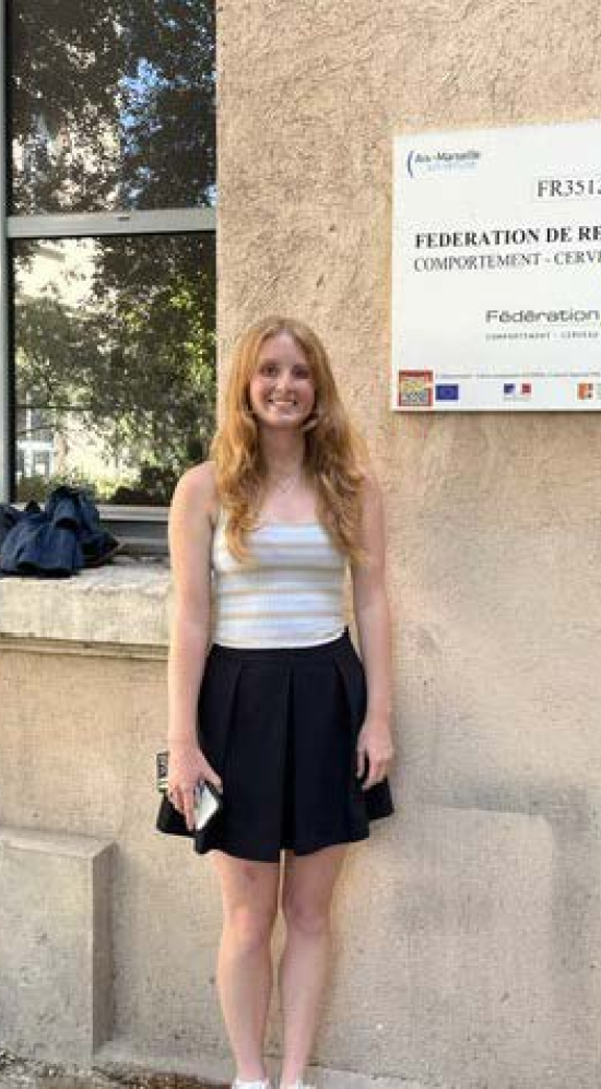 Catherine Haley in front of a building with the sign of the Federation De Recherche sign