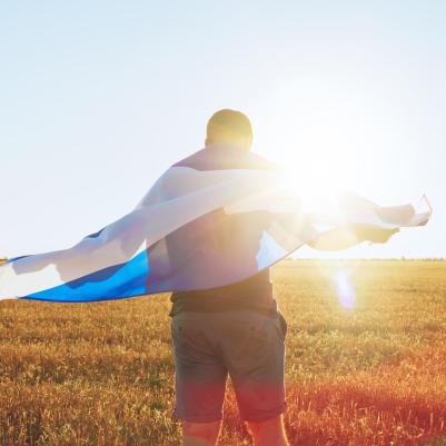 Man with flag of Scotland standing in a field.