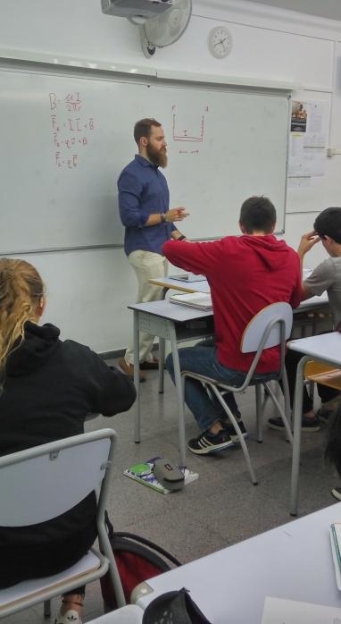 Nick Schwartz standing at a whiteboard and teaching a classroom full of students