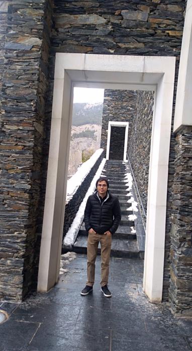 Nicolas Gomez standing at the bottom of a stairwell of a stone building.