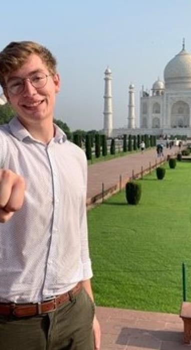 Richard Colwell showing off his class ring with the Taj Mahal in the background