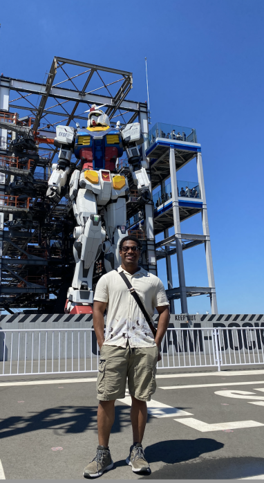 Zachary Francis standing in front of a huge giant robot