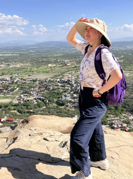 Amy on top of a mountain looking into the distance