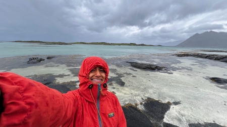 A selfie of Erin Menezes with the sea on a coudy day