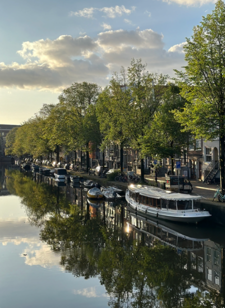 Sunset over the Amstel Rive with boats along the bank