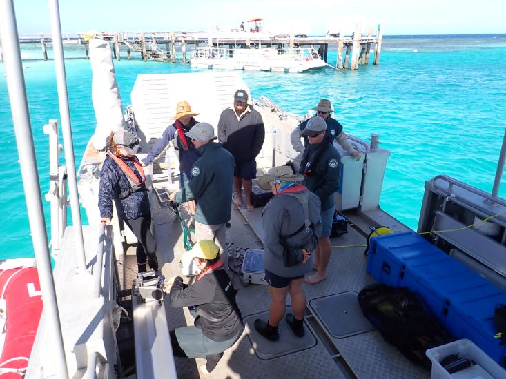 Annemarie Dapoz with AIMS team by the sea dock ready to deploy a reef scan with a crystal blue sea