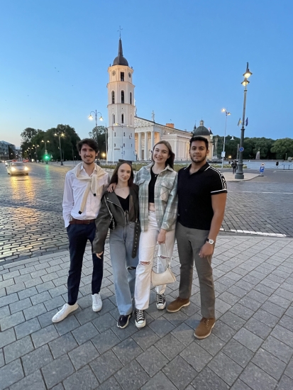 Rohan Deb (far right) with his friends in the Vilnius Old Town with Vilnius Cathedral in the back during the evening 
