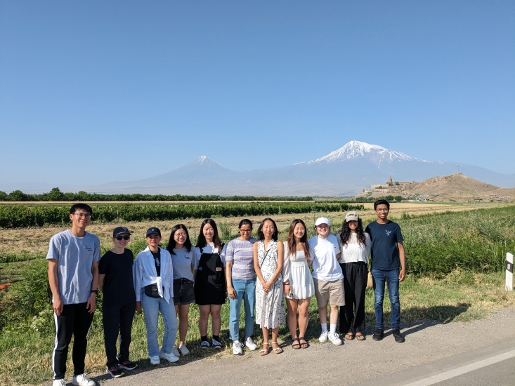 10 MIT students standing on the side of the road with two snowcapped mountains in the horizon in Armenia
