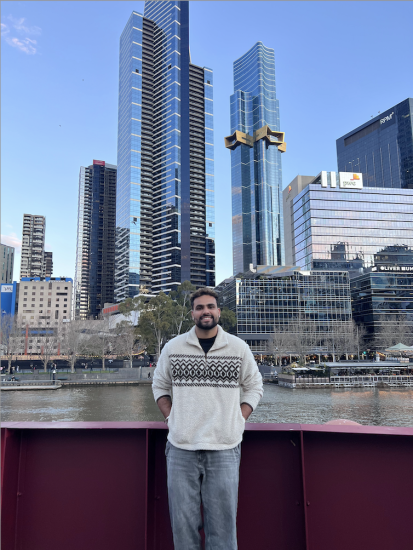 Darsh Grewal standing with hands in his pocket with the Melbourne tallest building in the background by the water