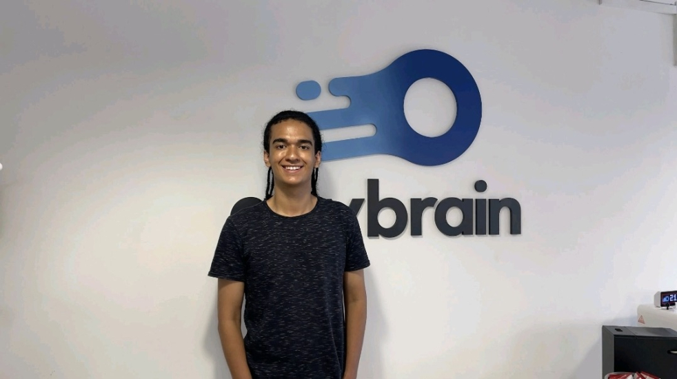 Gabriel Hemetrio standing in front of a logo by Anybrain