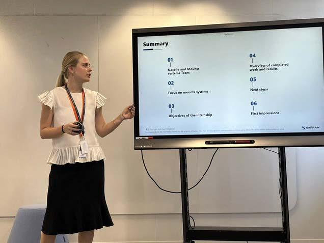 Skye W. looking at the screen while presenting a summary slide